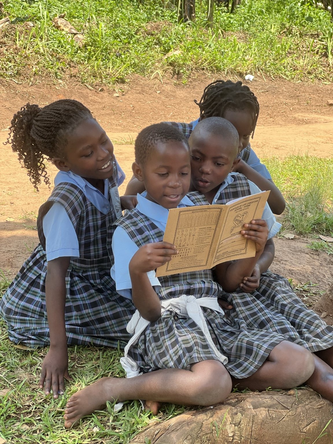 Children reading together outside at Fountain of Life Christian School