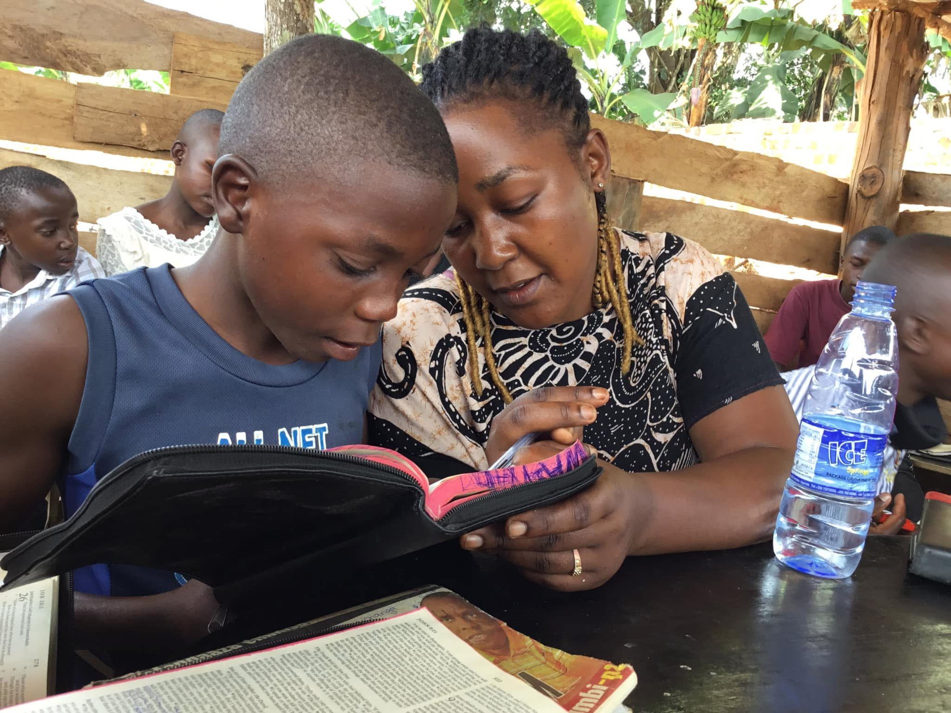 Claire helping a child read the Bible at FOLCS