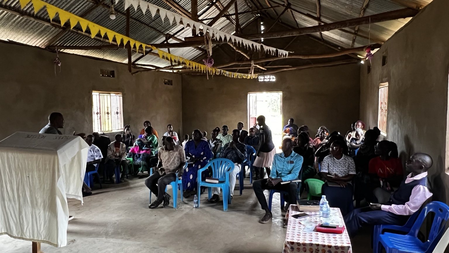 Pastor Kenneth Lule preaching from the Bible