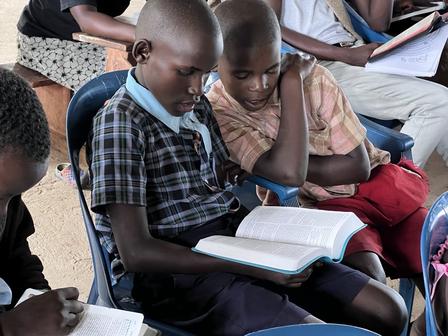 Two boys reading the Bible together